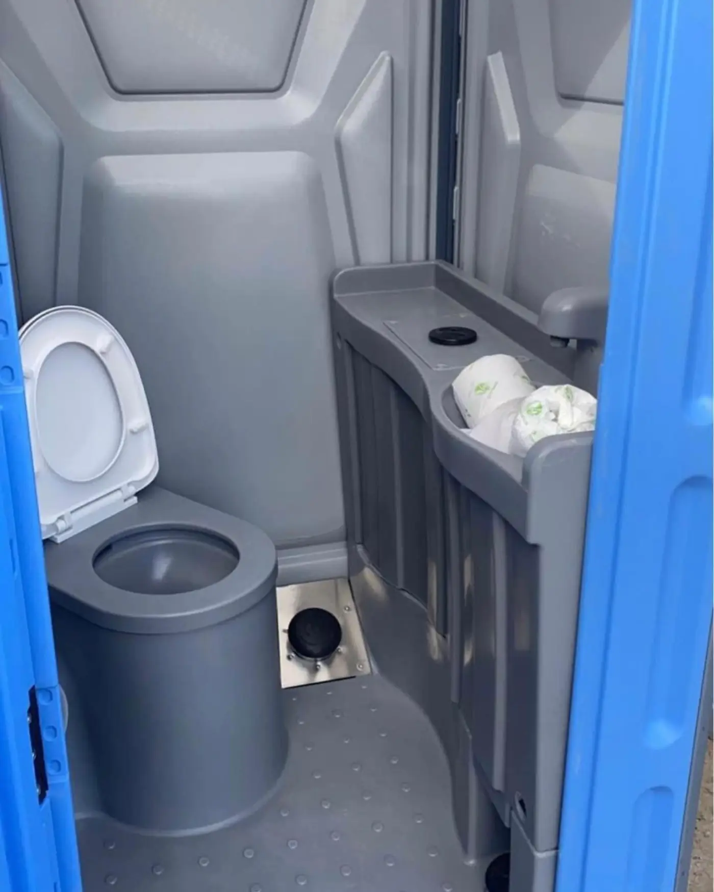 Deluxe porta potty interior showing the urinal next to the built-in hand wash sink