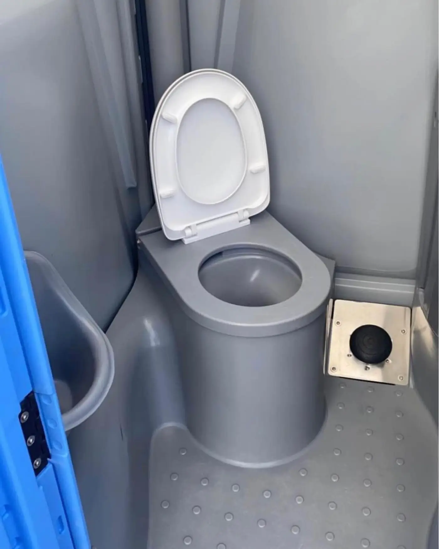 Interior of a blue portable toilet showing the seat and urinal